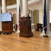 Amelia Reid at podium in Rotunda during thesis defense